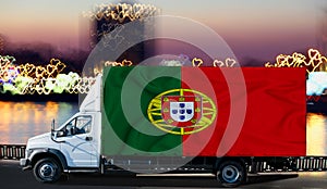 Portuguese flag on the side of a white van against the backdrop of a blurred city and river. Logistics concept