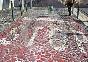 Portuguese Pavement Known as CalÃÂ§ada Portuguesa Made of Small White-Red-Black Stones in Mosaic Pattern With Stop Sign and photo