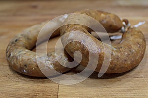 Portuguese smoked sausage called alheira on wooden board