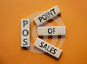 POS - Point Of Sales symbol. Wooden cubes with words POS. Beautiful orange background. Business and POS concept. Copy space