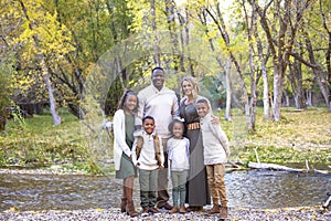Posed Mixed Race family portrait outdoors with autumn colors