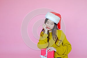asia woman wearing long sleeve clothes on pink background with gift box in hand, Christmas or X'mas and happy new year