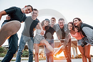 Posing for a camera. Group of young cheerful friends having fun together. Party outdoors