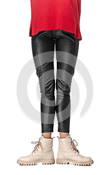 Slim legs of young girl in black leggings and boots isolated on white background