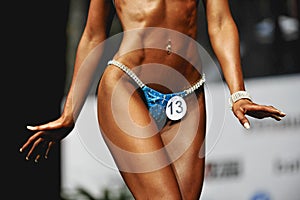 Posing woman model in swimsuit competition fitness bikini