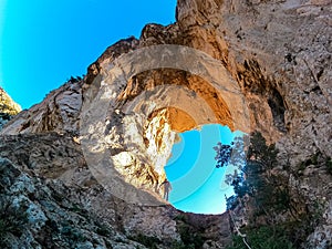 Positano - Man standing in the rock formation Montepertuso Il Buco in Positano and Praiano, Amalfi Coast, Campania, Italy, Europe.