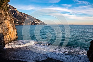 Positano - Scenic view at the Fornillo Beach in the coastal town Positano at Amalfi Coast, Italy. Praiano in distance