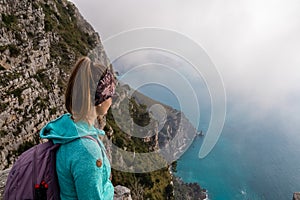 Positano - Woman with aerial panoramic view on the coastal road of the Amalfi Coast in the Provice of Salerno in Campania, Italy