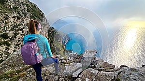 Positano - Woman with aerial panoramic view on the coastal road of the Amalfi Coast in the Provice of Salerno in Campania, Italy