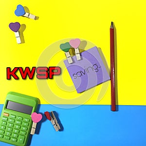 Position the calculator, pencil and note paper wording Saving with love clamps and also a written KWSP on background. Selective