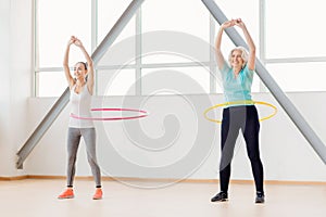 Positive active women rotating hula hoops