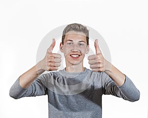 Positive adolescent boy in puberty showing thumbs up sign