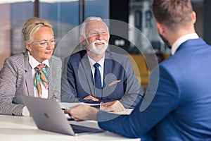 Positive aged couple consulting with insurance agent