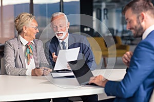 Positive aged couple consulting with insurance agent