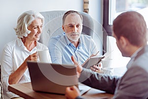 Positive aged couple consulting with insurance agent