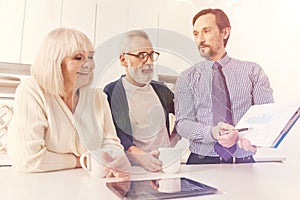 Positive aged couple meeting with real estate agent