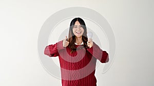 A positive Asian female is holding a light bulb and showing thumb up. isolated on white background