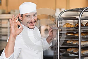 Positive baker checking freshly baked bread
