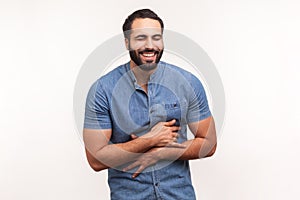 Positive bearded man holding his belly and laughing out loud, chuckling and hysterically laughing with anecdote, having fun photo
