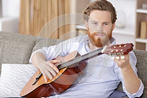 positive bearded man playing guitar photo