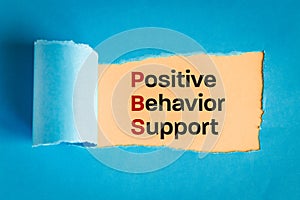 Positive behavior support symbol. text appearing behind torn paper, blue background, concept words support positive behavior