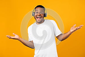 Positive Black Guy In Headphones Listening Music Posing In Studio