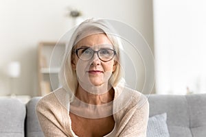 Positive blonde senior mature woman in glasses looking at camera