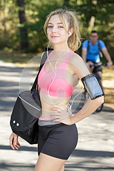 positive blonde woman before sporting in park