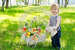 Positive boy with watering can and flowers