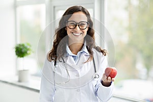 Positive brunette woman wearing medical coat and eyeglasses doctor