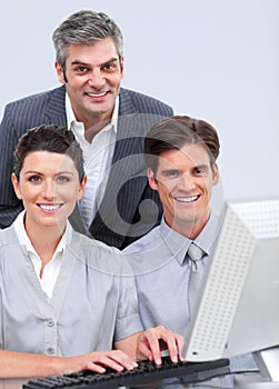 Positive business team working at a computer