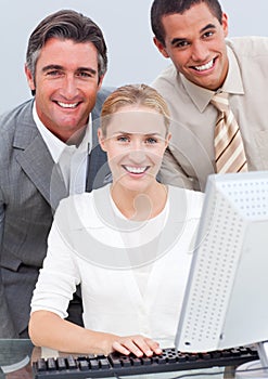 Positive business team working at a computer