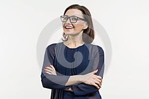 Positive business woman of middle age posing over white with arms crossed.