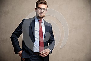 Positive businessman adjusting his tie and standing