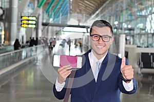 Positive businessman giving thumbs up during trip
