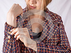 Positive businesswoman fastens button on tweed jacket