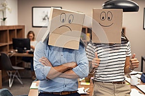 Positive businesswoman and negative man covering face with cardboard
