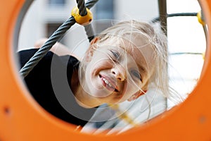 Positive carefree child smiling at the playground, portrait