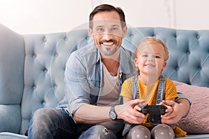 Positive caring father teaching his daughter to play video games