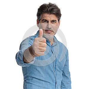 Positive casual man giving a thumbs up and smiling