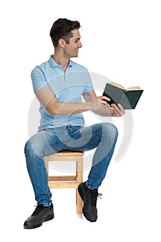 Positive casual man preseting a book to the side