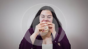 Positive Caucasian obese girl eating sandwich. Plump woman with overweight problem eating unhealthy food. Obesity