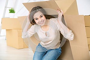 Positive charming girl hiding under the box