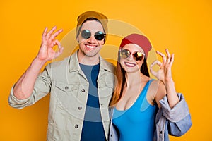 Positive cheerful couple enjoy summer rest relax show okay sign recommend excellent feedback wear shirt denim jeans