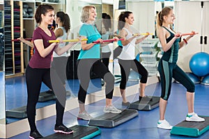 Positive females working out on aerobic step platform