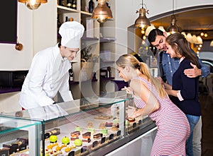 Positive chef man is serving visitors