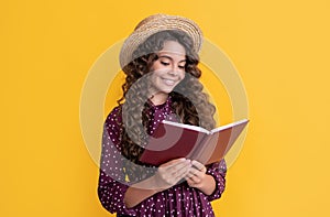 positive child with frizz hair read book on yellow background