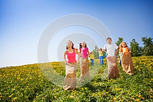 Positive children jump in sacks and playing