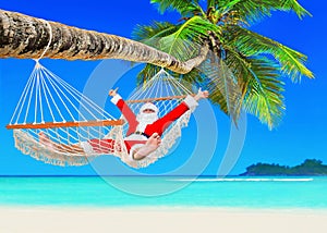 Positive Christmas Santa Claus relax in hammock at palm beach