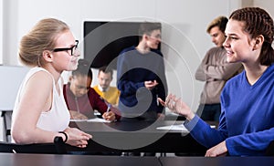 positive classmates having animated talks at break between classes